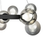 Nahaufnahme einer modernen LED-Hängeleuchte mit mehreren kugelförmigen Glaskörpern, seitliche Perspektive.