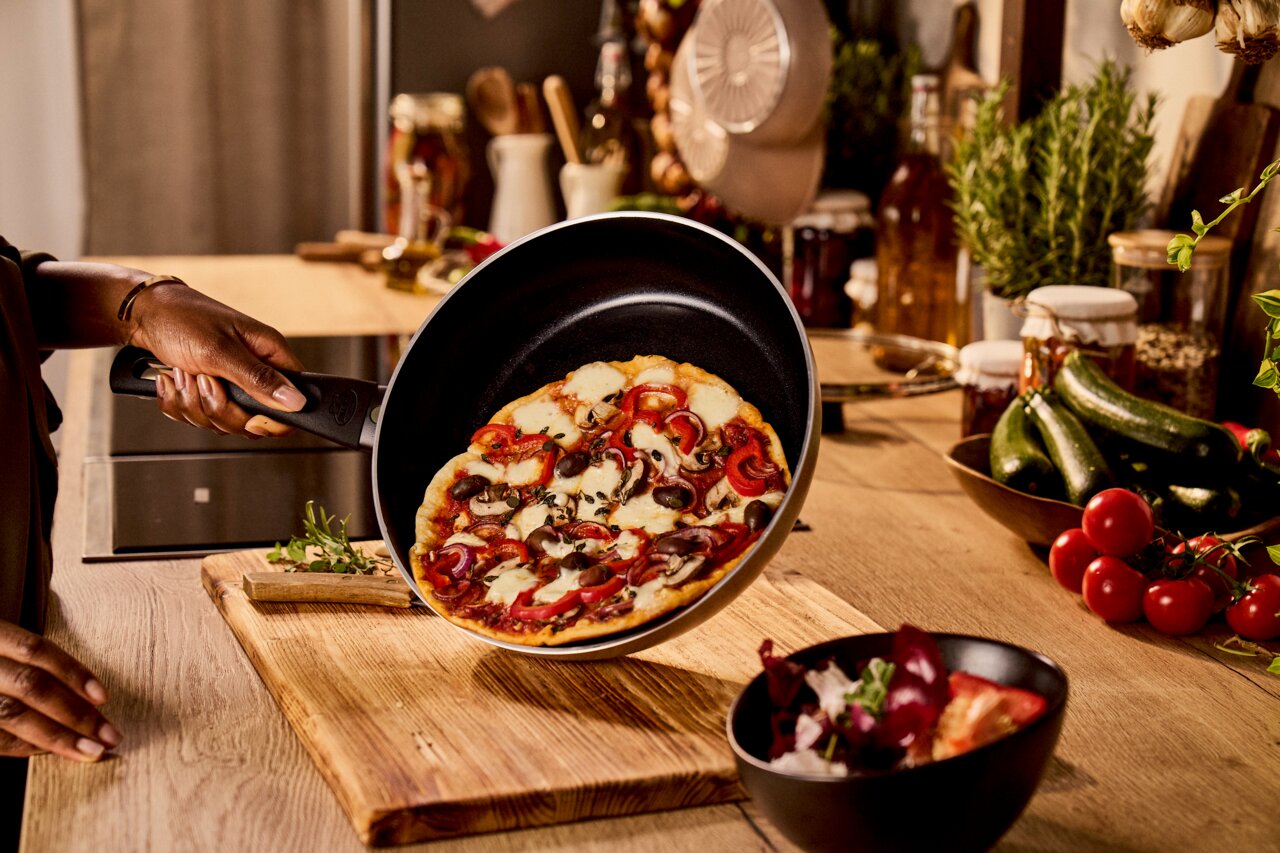 Bratpfanne mit Pizza, seitliche Perspektive in einer Küche