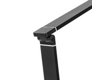 Nahaufnahme einer modernen, schwarzen Schreibtischleuchte mit verstellbarem Arm, seitliche Perspektive.