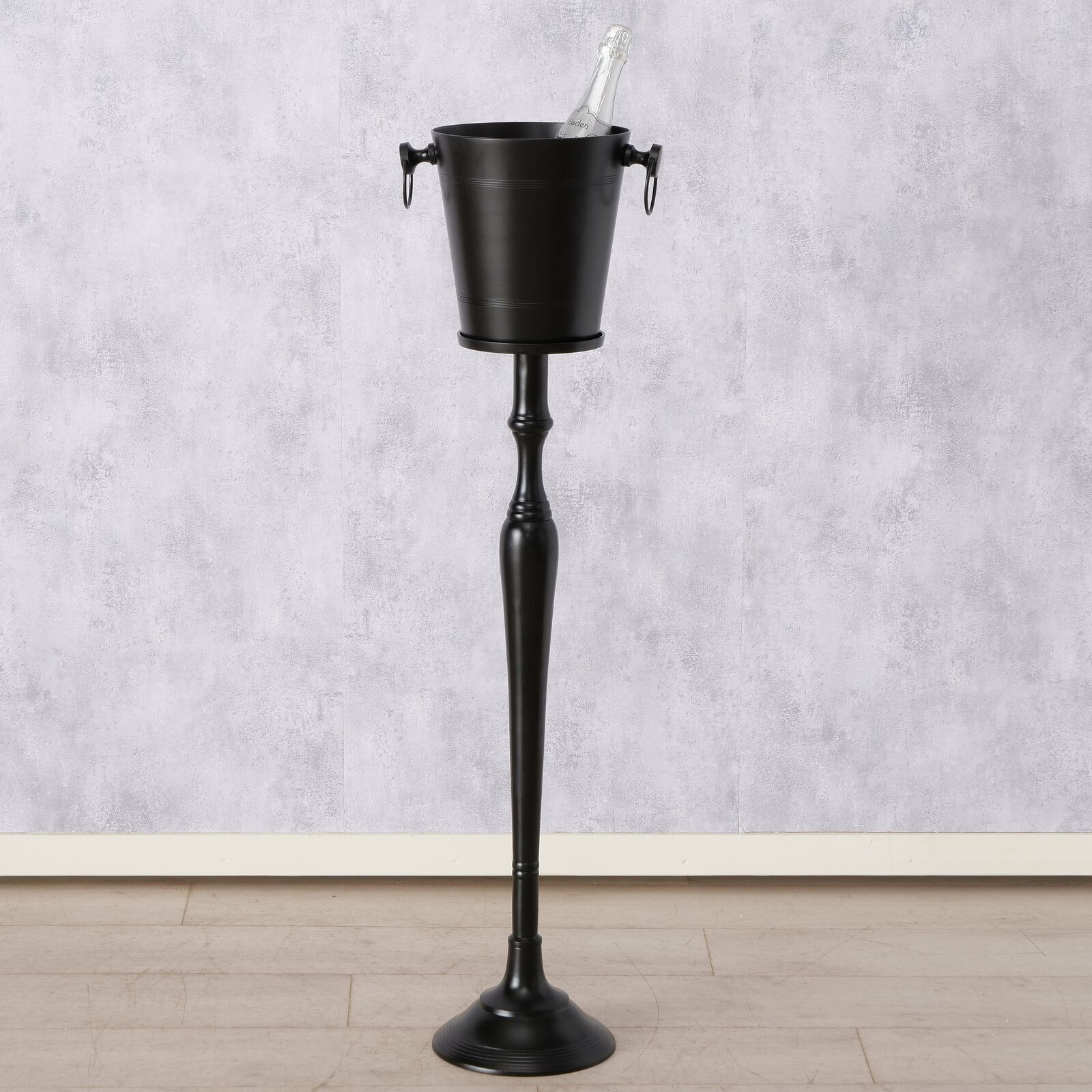 Eleganter, runder Weinkühler Amara auf hohem, schlankem Ständer, frontal abgebildet, mit einer Flasche im Eiskübel.