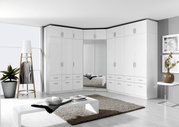 Eckschrank mit weißen Drehtüren und Schubladen, moderne Einrichtung in einem hellen Raum, Perspektive von vorne