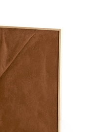 Detailansicht aus leichter Frontperspektive auf eine braune, samtig strukturierte Paneelfläche mit geometrischer Linienprägung und schmalem Rahmen aus hellem Holz