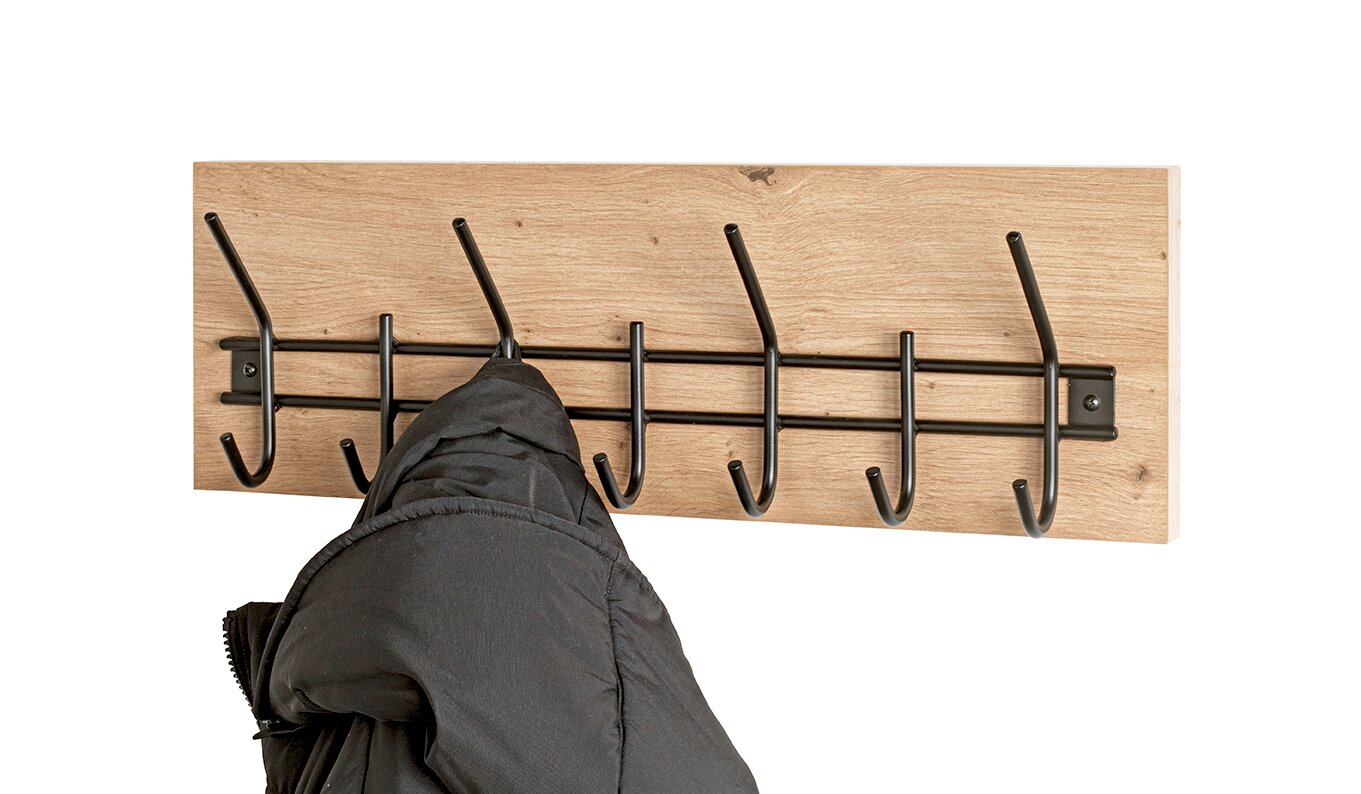 Wandgarderobe aus hellem Holz mit schwarzer Metall-Hakenleiste und mehreren Doppelhaken, frontal aufgenommen; ein dunkler Mantel hängt an einem Haken