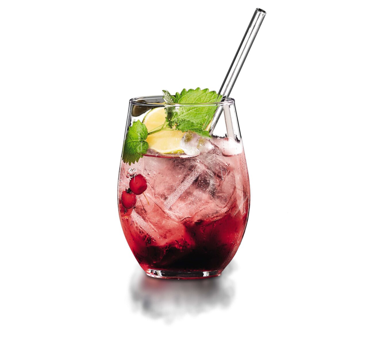 Close-up van een gin-cocktail in een glas met ijsblokjes, rode bessen, schijfjes citroen en een rietje, versierd met verse muntblaadjes.