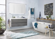 Moderne Badezimmerkombination mit grauem Waschtisch, großem Spiegel und freistehender Badewanne, seitliche Perspektive