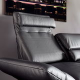 Nahaufnahme eines schwarzen Ledersofas mit verstellbarer Kopfstütze, seitliche Perspektive.