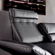 Nahaufnahme eines schwarzen Ledersofas mit verstellbarer Kopfstütze, seitliche Perspektive.
