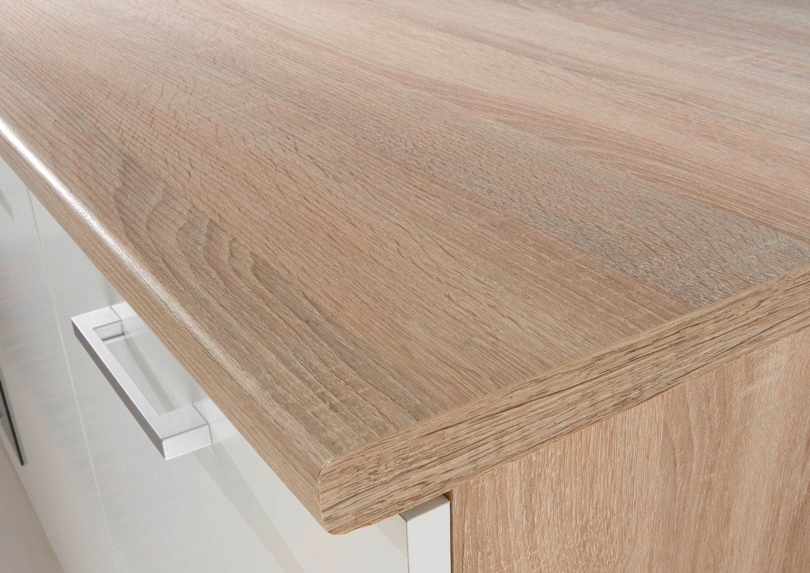 Nahaufnahme einer Küchenarbeitsplatte in Holzoptik mit moderner Metallgriffleiste, Perspektive von oben.
