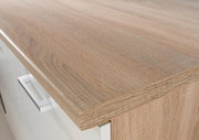 Nahaufnahme einer Küchenarbeitsplatte in Holzoptik mit moderner Metallgriffleiste, Perspektive von oben.