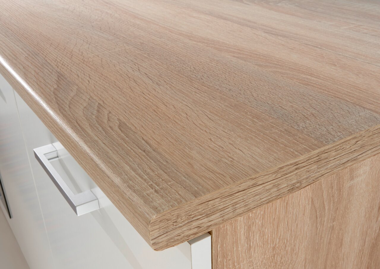 Nahaufnahme einer Küchenarbeitsplatte in Holzoptik mit moderner Metallgriffleiste, Perspektive von oben.