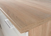 Nahaufnahme einer Küchenarbeitsplatte in Holzoptik mit moderner Metallgriffleiste, Perspektive von oben.