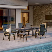 Moderner Hocker auf einer Terrasse neben einem Esstisch mit Stühlen, Blick von der Seite