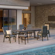 Moderner Hocker auf einer Terrasse neben einem Esstisch mit Stühlen, Blick von der Seite