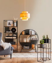 Ein stilvolles Wohnzimmer mit modernen schwarzen Regalen und einem Blumenständer-Set, dekoriert mit Pflanzen und Accessoires. Die Perspektive zeigt die Regale und den Blumenständer von vorne.