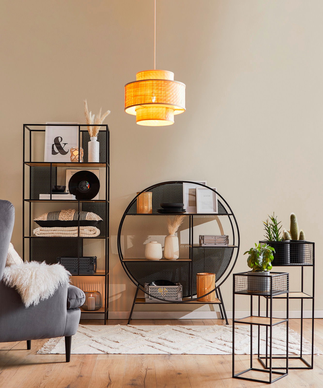 XORA Regal LEON Ein stilvolles Wohnzimmer mit modernen schwarzen Regalen und einem Blumenständer-Set, dekoriert mit Pflanzen und Accessoires. Die Perspektive zeigt die Regale und den Blumenständer von vorne.