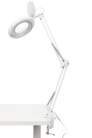 Weiße Schreibtischleuchte mit verstellbarem Arm, seitliche Perspektive, an einem Tisch befestigt.