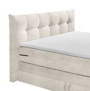 Beige Boxspringbett mit gestepptem Kopfteil, seitliche Perspektive