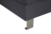 Nahaufnahme einer grauen Sofaecke mit Metallfuß, Perspektive von unten.