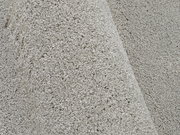 Nahaufnahme eines hellgrauen Uni-Teppichs mit weicher, flauschiger Textur, seitliche Perspektive