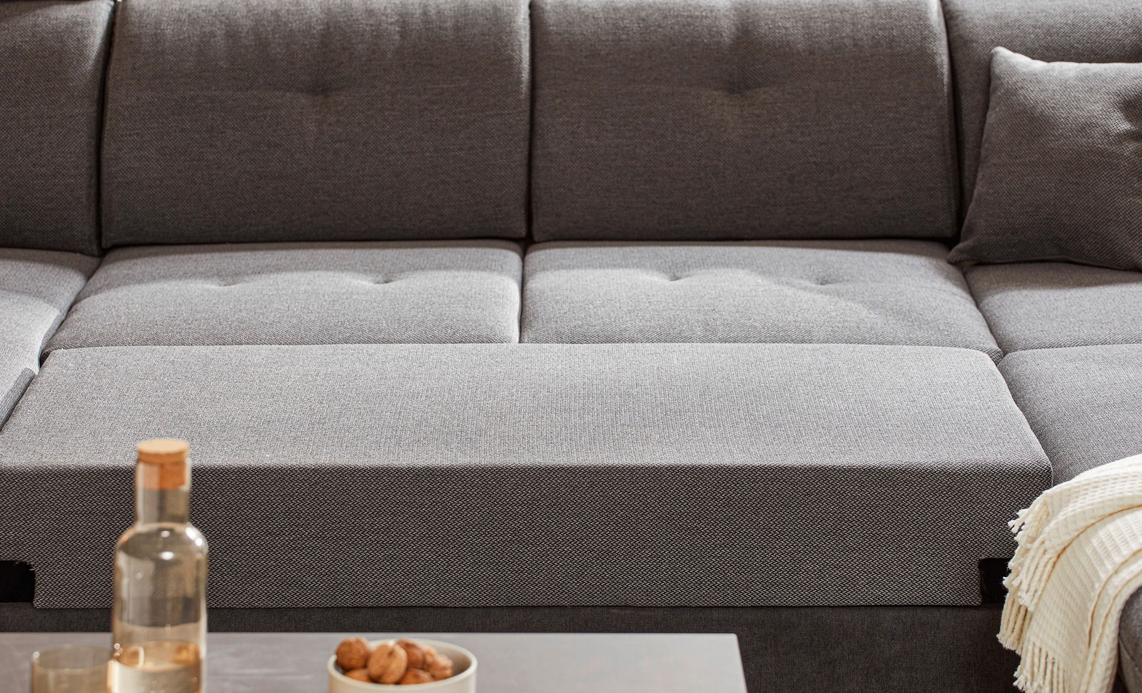 Graues Sofa mit Kissen und Decke, Vorderansicht