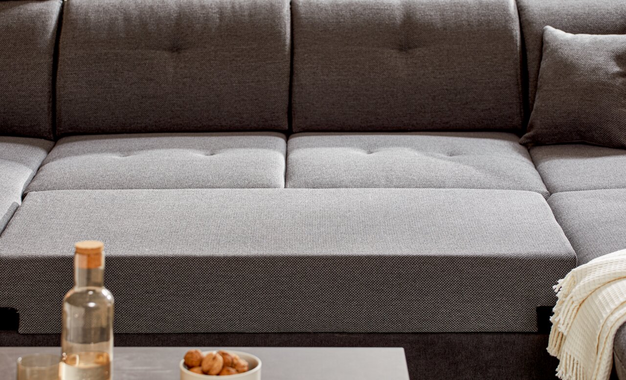 Graues Sofa mit Kissen und Decke, Vorderansicht
