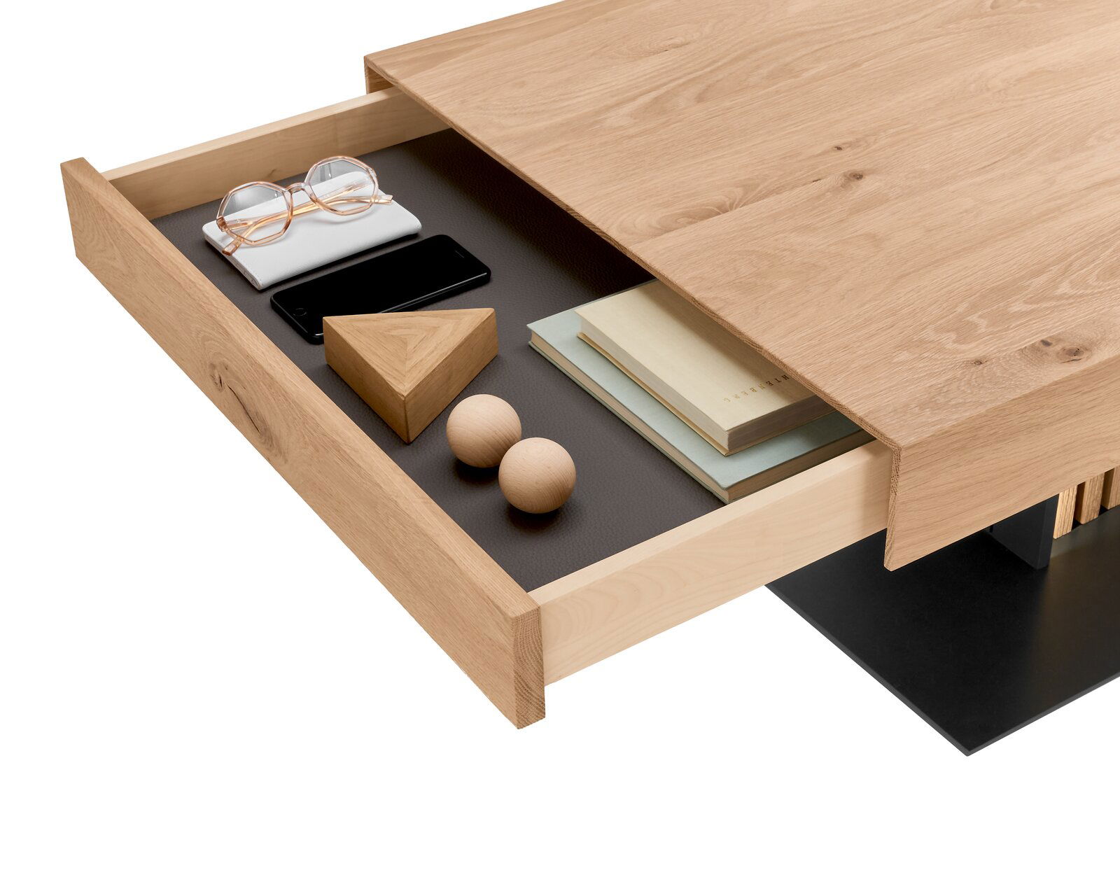 Nahaufnahme eines Couchtisches aus Holz mit geöffneter Schublade, die Bücher, eine Brille, ein Smartphone und dekorative Holzelemente enthält. Perspektive von oben.