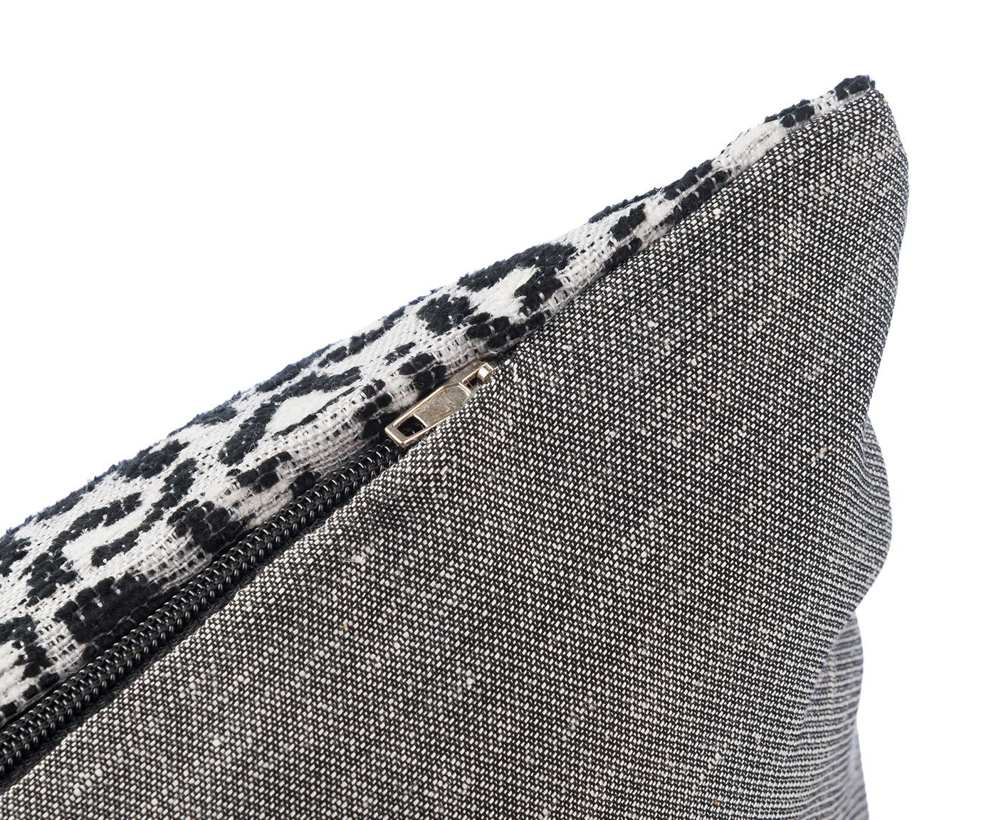Nahaufnahme einer Kissenhülle mit Reißverschluss, schwarz-weiß gemustert, seitliche Perspektive