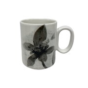 Weiße Tasse mit schwarzem Blumenmuster, seitliche Perspektive