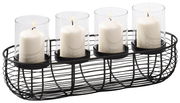 Dekorativer Kerzenhalter mit vier weißen Kerzen in Glaszylindern, präsentiert in einem schwarzen Metallkorb, seitliche Perspektive.