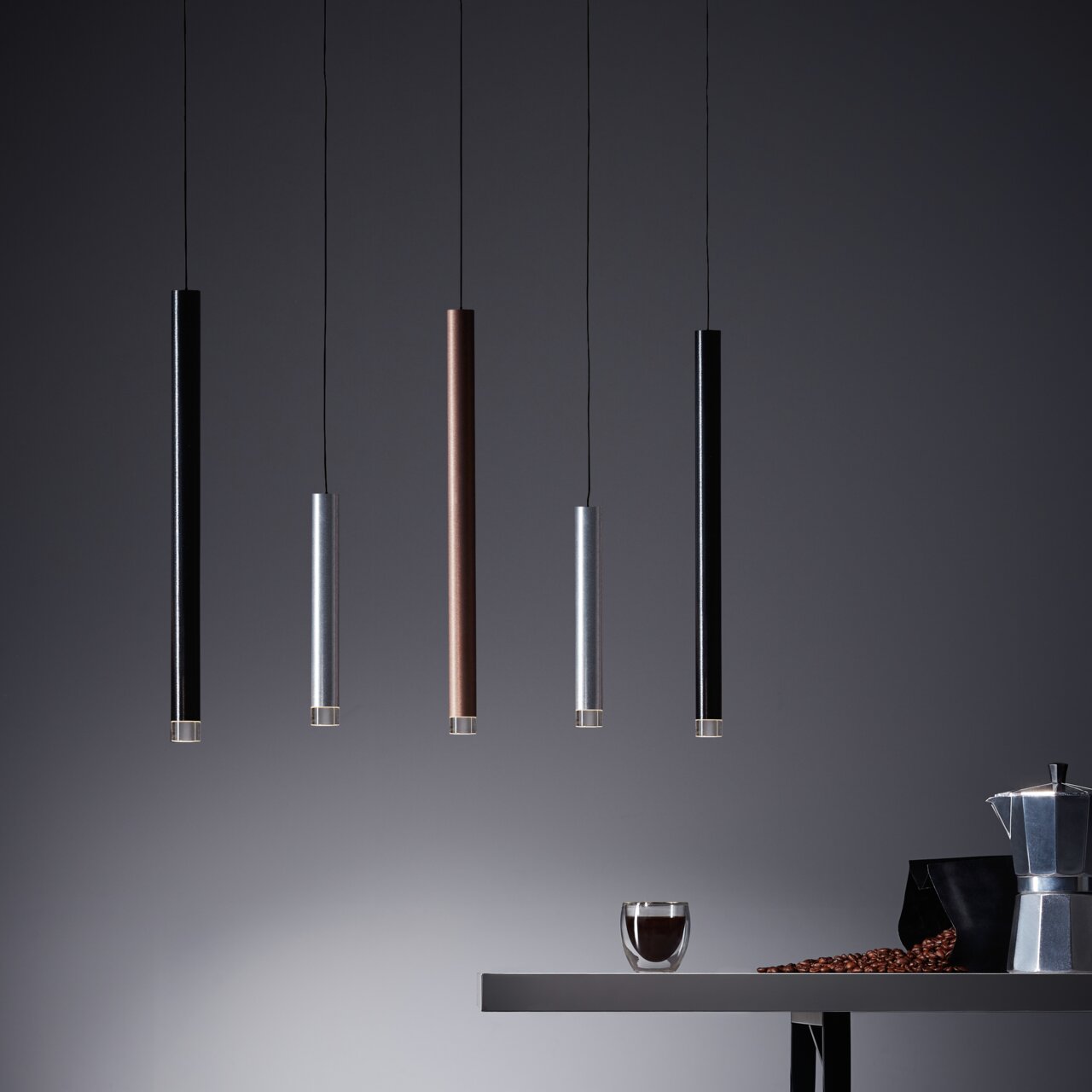 Moderne hanglamp met vijf cilindervormige ledlampen in verschillende kleuren, gezien vanaf de zijkant.