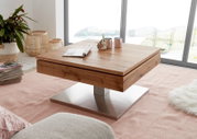 Moderne houten salontafel met metalen onderstel, in een lichte woonkamer met grote ramen, gezien vanaf de zijkant.