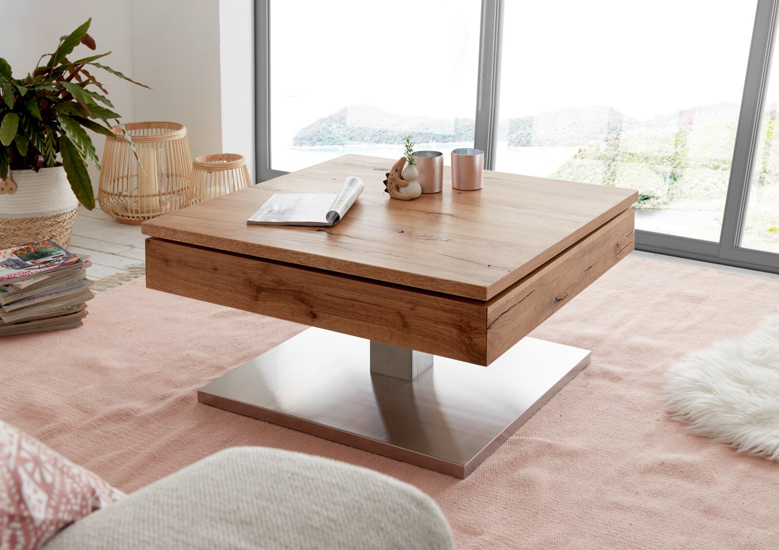 Moderne houten salontafel met metalen onderstel, in een lichte woonkamer met grote ramen, gezien vanaf de zijkant.