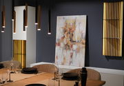 Der Esstisch angeschnitten im Vordergrund, dahinter mehrere beleuchtete Schrank-Elemente und ein großes abstraktes Gemälde in der Mitte.