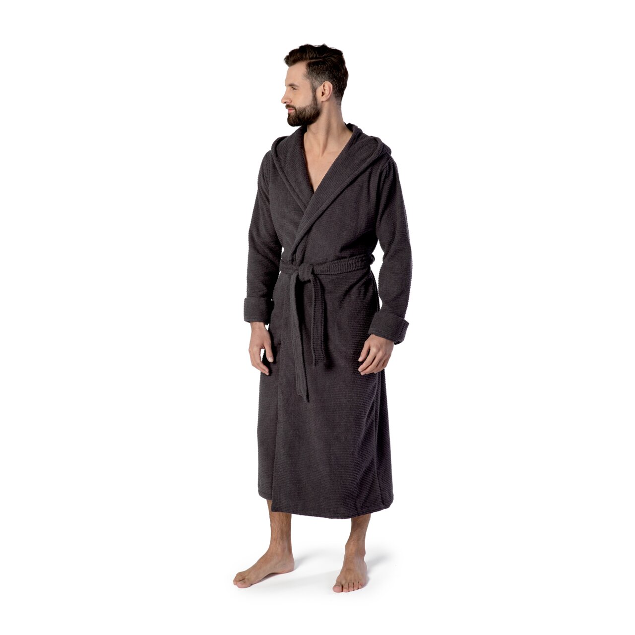 Mann in einem dunkelgrauen Kapuzenbademantel, stehend in seitlicher Perspektive.