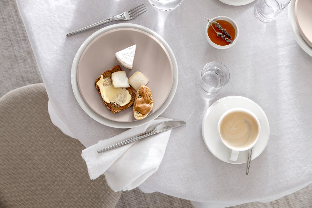 Frühstücksteller NewMoon 24cm mit Käse und Brot, von oben fotografiert auf einem gedeckten Tisch.