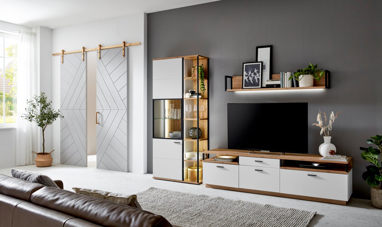 Moderne Wohnzimmer-Wandkombination mit TV-Schrank, Vitrine und Regal in Holz- und Weißtönen, seitliche Perspektive