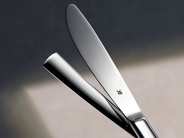 Poliertes Edelstahl-Buttermesser mit WMF-Logo, schräg von oben fotografiert, vor neutralem Hintergrund