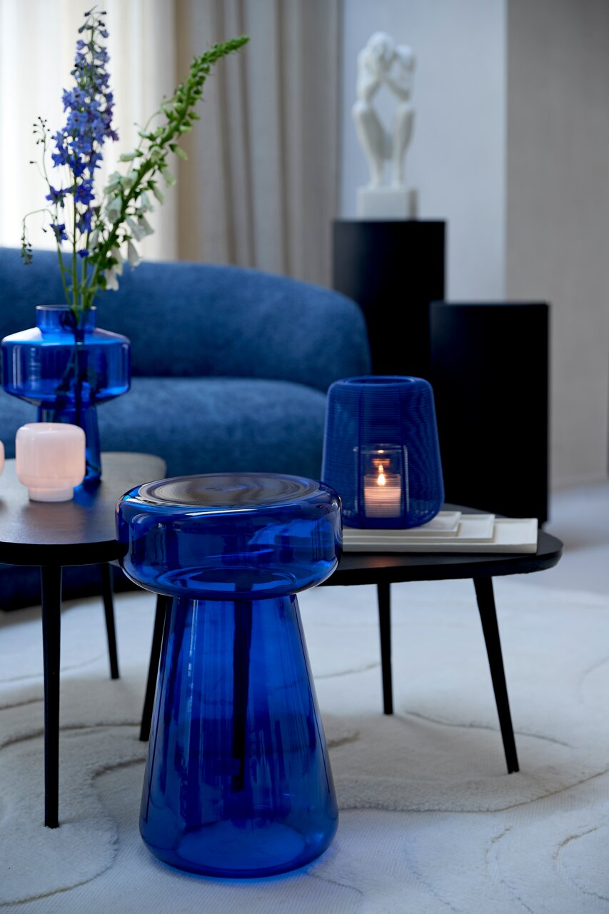 Blaue Glasschale in moderner Wohnzimmerumgebung, seitliche Perspektive