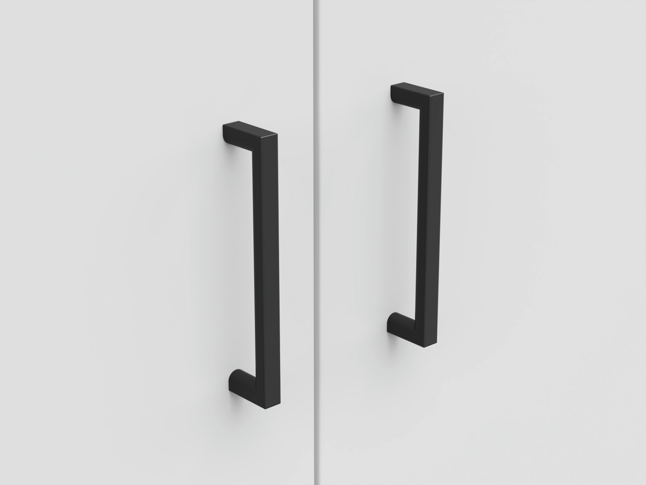 Nahaufnahme von zwei schwarzen Griffen an einer weißen Schranktür, frontal betrachtet.