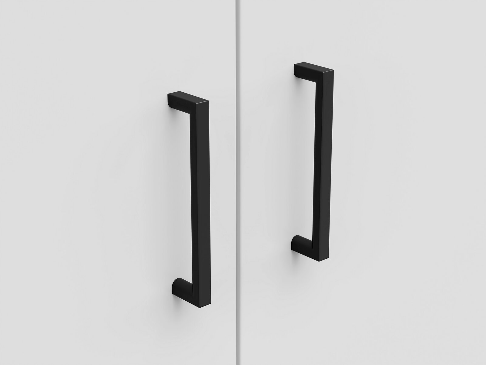 Nahaufnahme von zwei schwarzen Griffen an einer weißen Schranktür, frontal betrachtet.