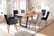 Moderne eettafel met houten blad en zwarte metalen poten, omringd door gestoffeerde stoelen in een lichte eetkamer. Zijaanzicht.