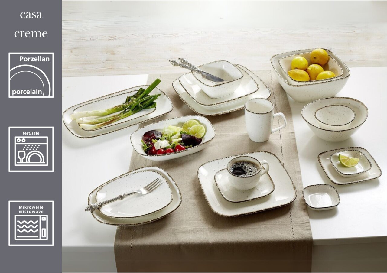 Beige Dipschale aus Porzellan, rechteckig mit abgerundeten Ecken, auf einem gedeckten Tisch von oben fotografiert.