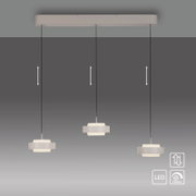 Moderne LED-hanglamp met drie lampen in wit, met een langwerpige kap en in hoogte verstelbare kabels; vooraanzicht, licht van onderaf gefotografeerd tegen een grijze achtergrond
