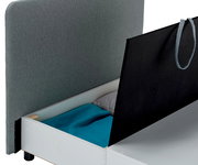 Funktionssessel mit Stauraum, seitliche Perspektive, geöffnet mit Kissen und Decke.