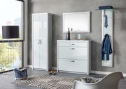 Moderne Garderobeneinrichtung mit weißem Schuhschrank, Spiegel und Garderobenpaneel in einem hellen Raum mit Blick aus dem Fenster.