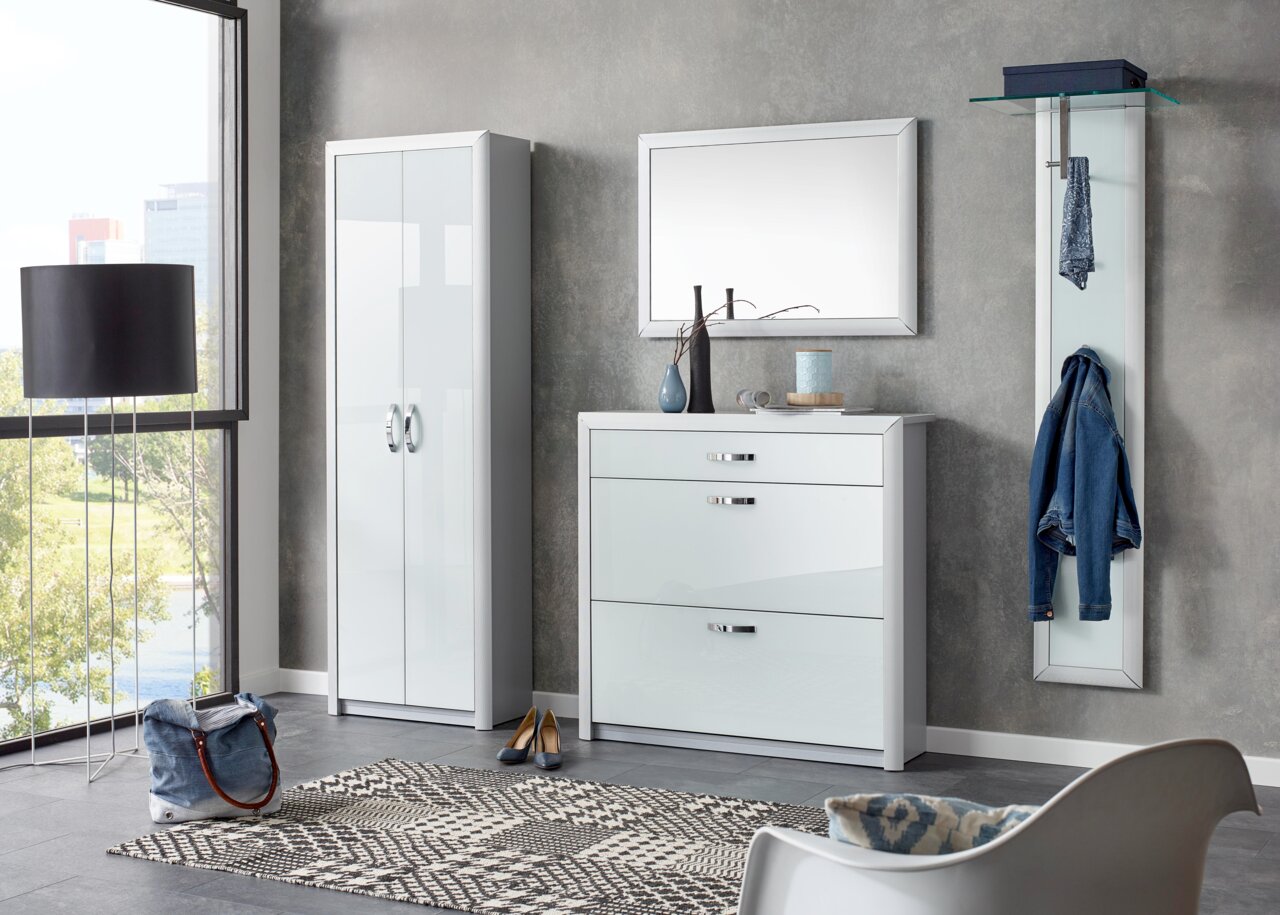 Moderne Garderobeneinrichtung mit weißem Schuhschrank, Spiegel und Garderobenpaneel in einem hellen Raum mit Blick aus dem Fenster.