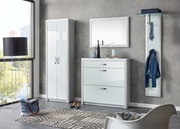 Moderne Garderobeneinrichtung mit weißem Schuhschrank, Spiegel und Garderobenpaneel in einem hellen Raum mit Blick aus dem Fenster.