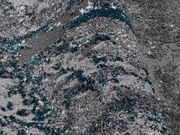 Nahaufnahme eines grauen Teppichs mit blauen Akzenten, perspektivisch von der Seite aufgenommen.