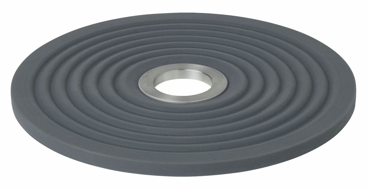 Runder, grauer Untersetzer mit konzentrischen Kreisen und einer Metallöffnung in der Mitte, seitliche Perspektive.