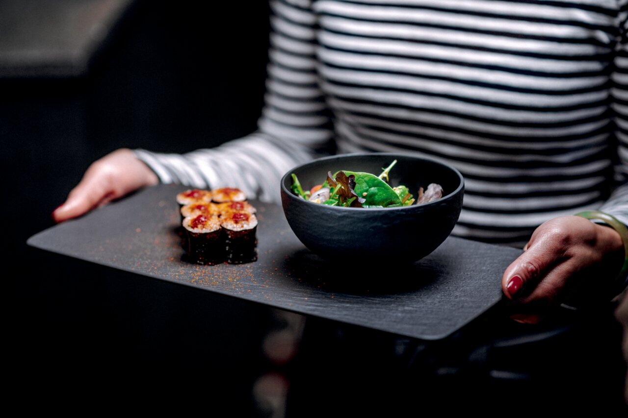 Villeroy & Boch Bowl MANUFACTURE ROCK Schale Manufacture 200ml mit Salat, präsentiert auf einem Tablett aus der Perspektive einer Person, die es in den Händen hält.